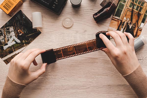 Old,film,negative,holding,by,a,teenage,girl,,retro,background